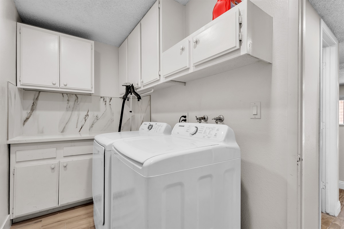 Laundry room with laundry detergent and garment steamer
