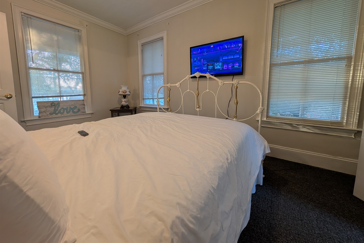 Upstairs guest bedroom with smart tv and queen bed