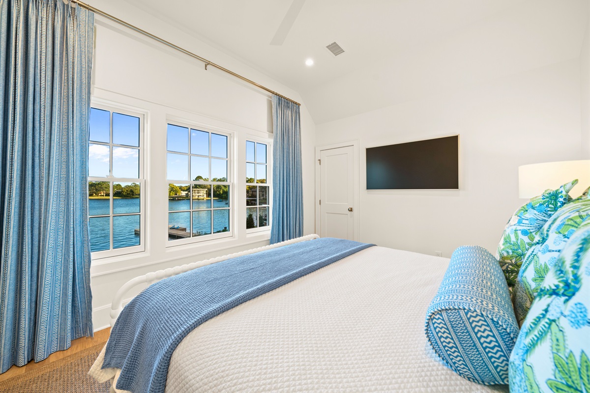 Comfortable guest room with large windows and natural light.