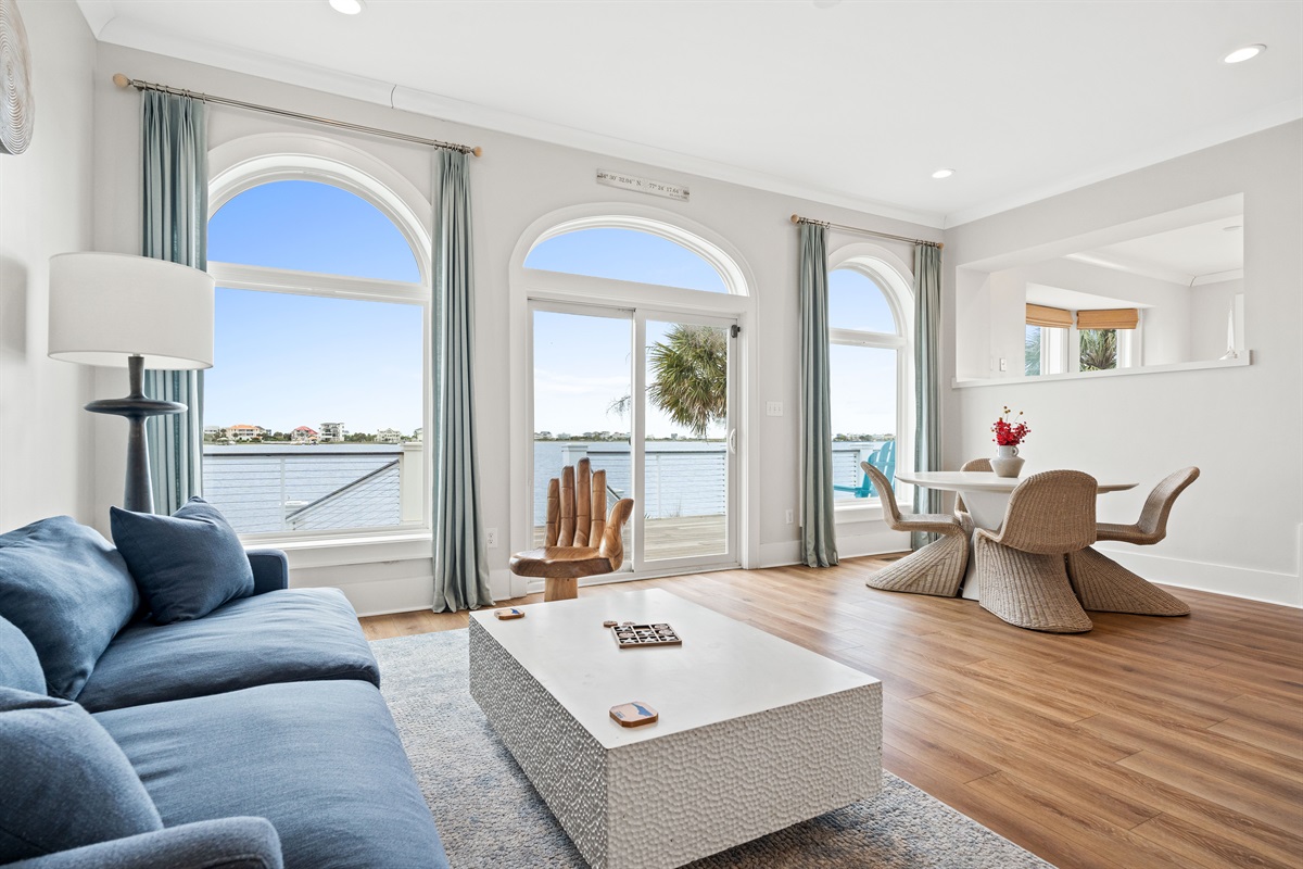 Sun-filled waterfront sitting area with soaring windows and direct deck access for enjoying the incredible views