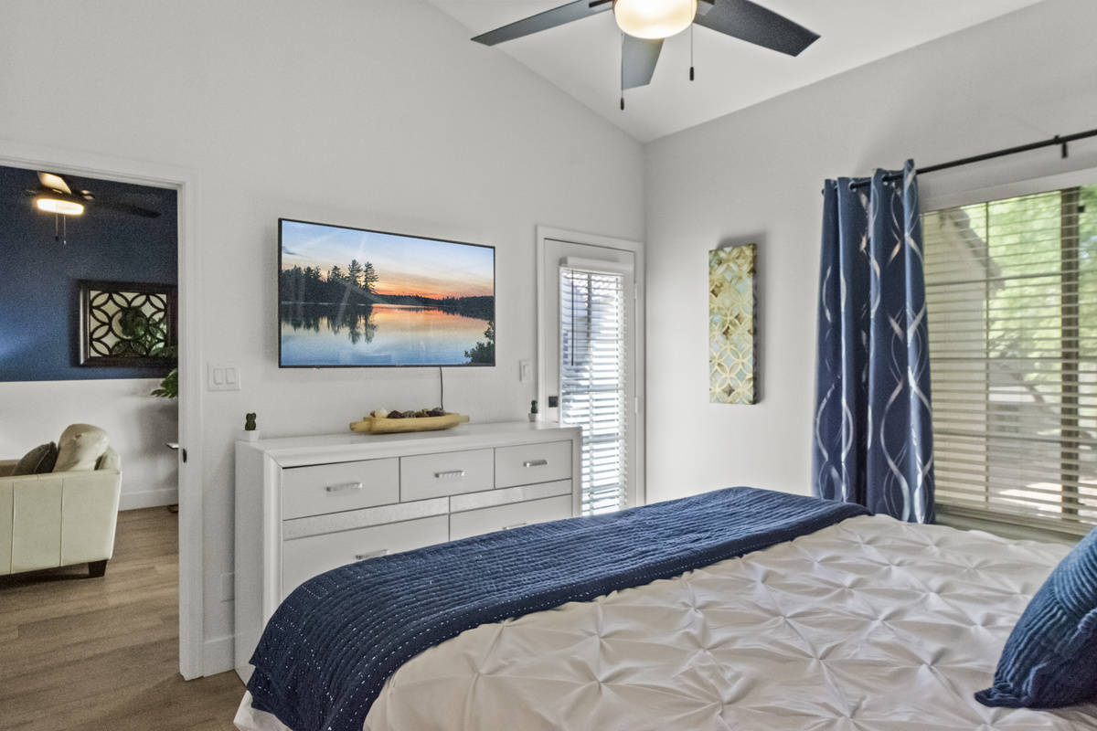 Another calming bed space for guests that features a Roku Smart TV, windows, and a comfortable hybrid mattress. 