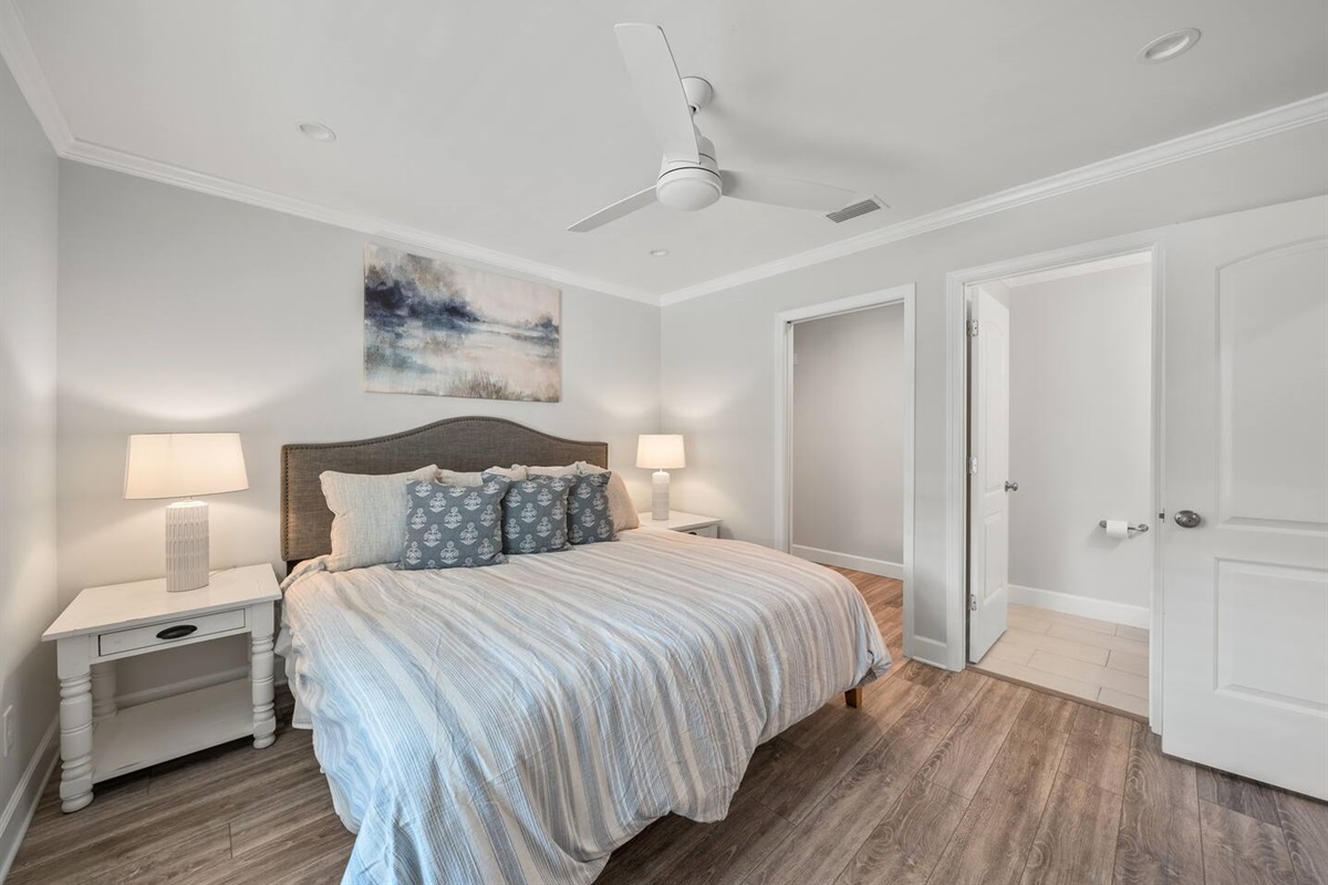 Master bedroom of Unit B with a king bed, TV and half bathroom. 