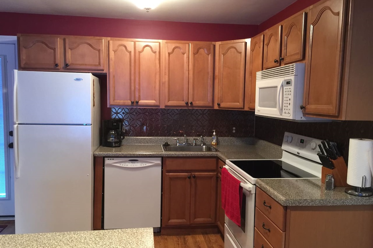 Kitchen stocked with pots and pans, spices, microwave, dishwasher, disposal, ice maker, coffee pot, refrig, electric range, and more!