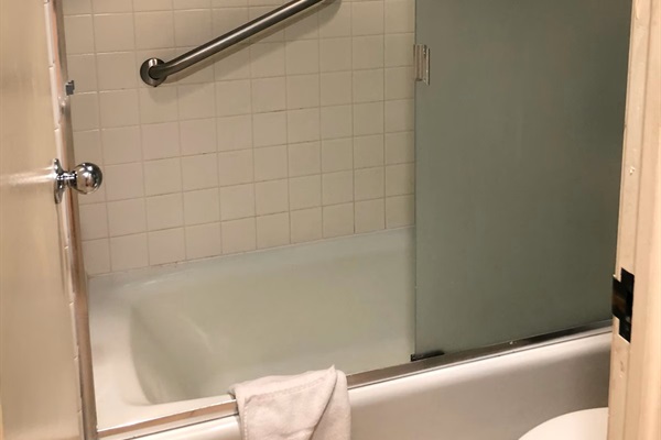 Clean bathroom with shower-tub combination