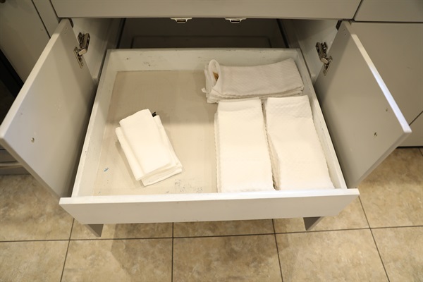 Kitchen cabinet showing pull out drawers with kitchen towels and washcloths