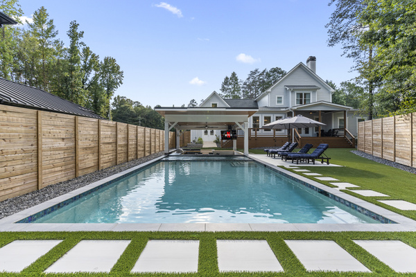 Backyard oasis with large swimming pool (5'6" deep), sun lounge chairs, gazebo with outdoor kitchen and dining area and large screen TV, and an extra tall privacy fence.