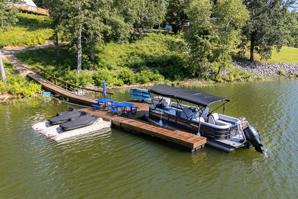 Private lakefront dock with pontoon boat rental, jet ski slips, and lakeside seating — steps from your dome.