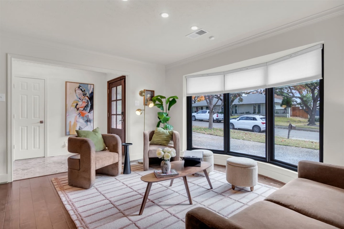 Stylish sitting area with two comfortable chairs, curated artwork, and design-forward accents, creating a cozy yet elegant space to relax, read, or enjoy a quiet moment while staying connected to the home’s open layout.