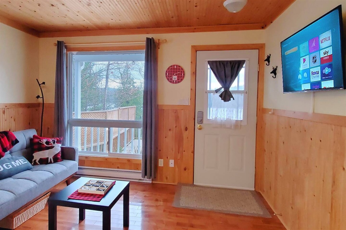 Living room seating area with doors out to deck and BBQ area