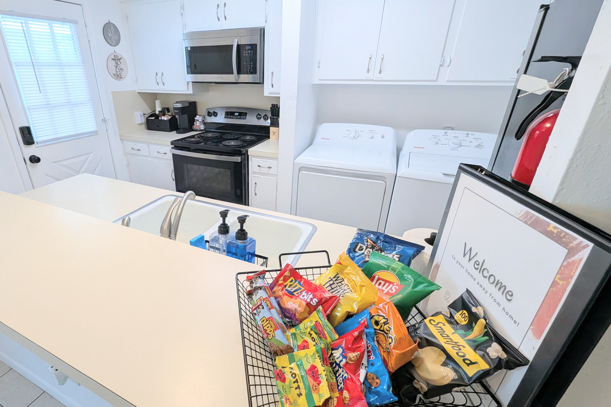 Kitchen is fully stocked and has direct access to the backyard courtyard, patio, and carport. 
