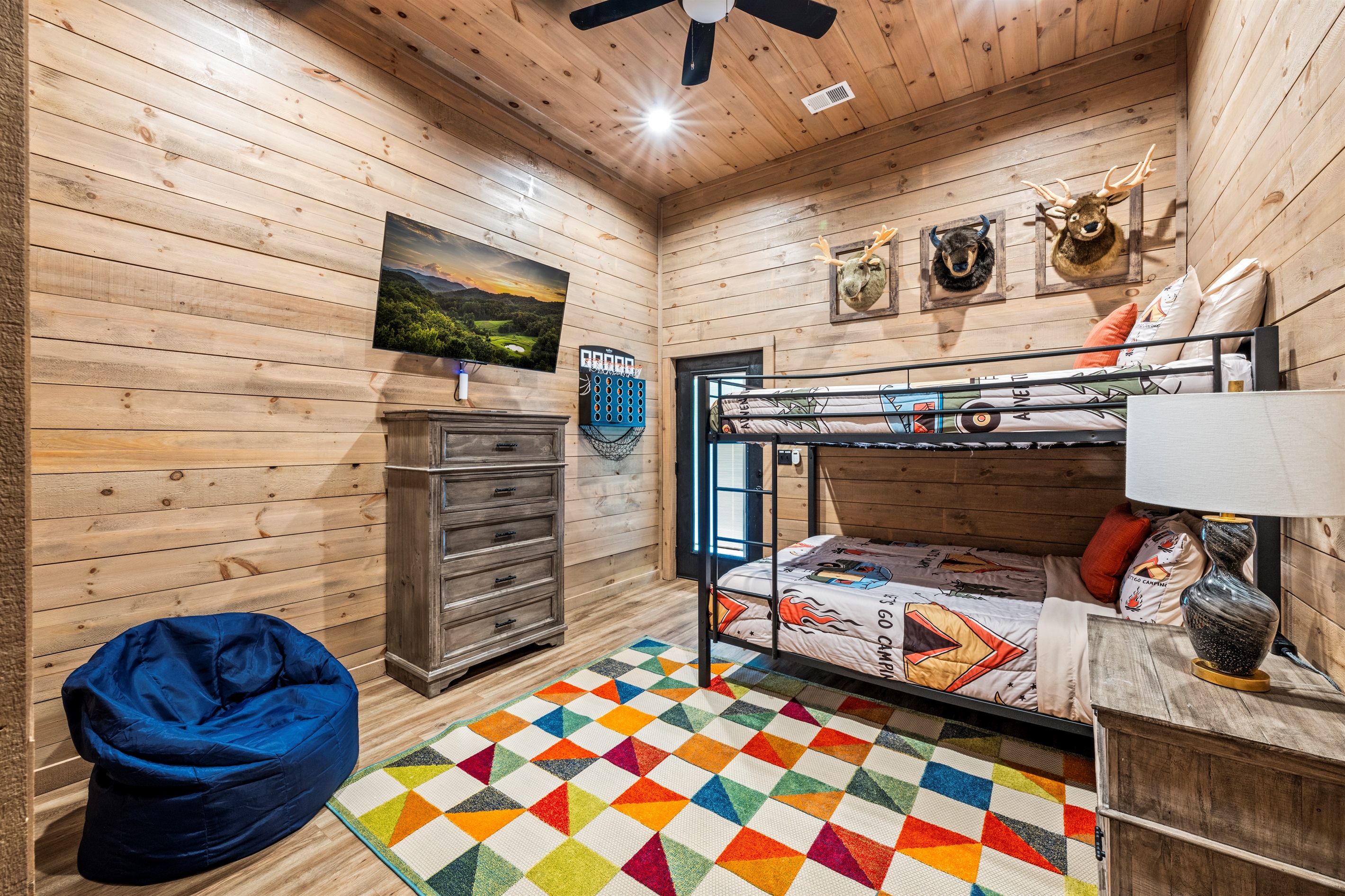 🧒 Camp vibes, but better! Bunks, bean bags, a big-screen TV, and wild wall decor make this room every kid's favorite.