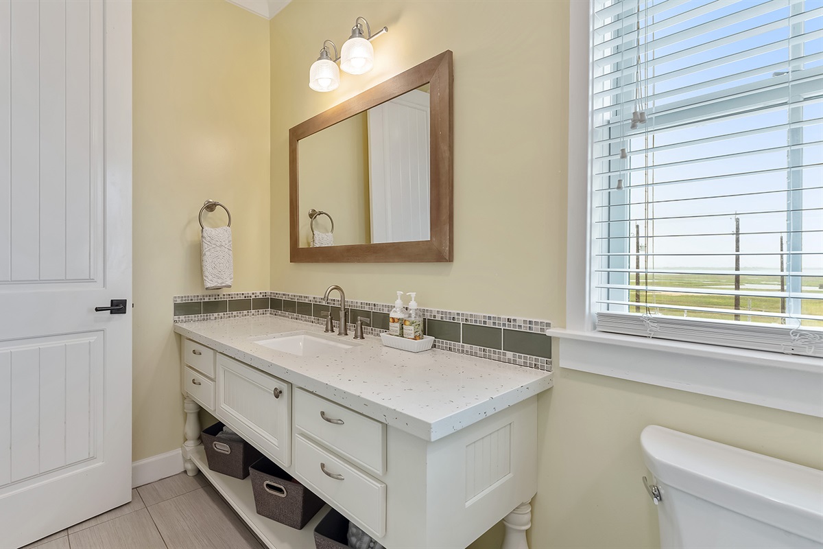 Full Bathroom #1: Single sink with natural light and plenty of storage.