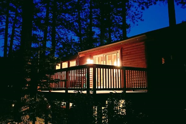 The home glows beautifully at night, creating a warm and inviting outdoor space under the stars.  
