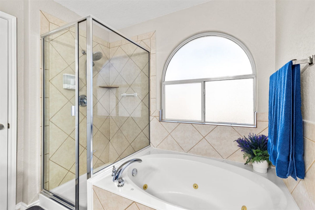Spacious master ensuite featuring a double vanity, standalone shower, and soothing jacuzzi spa bathtub—perfect for unwinding after a day in San Antonio.