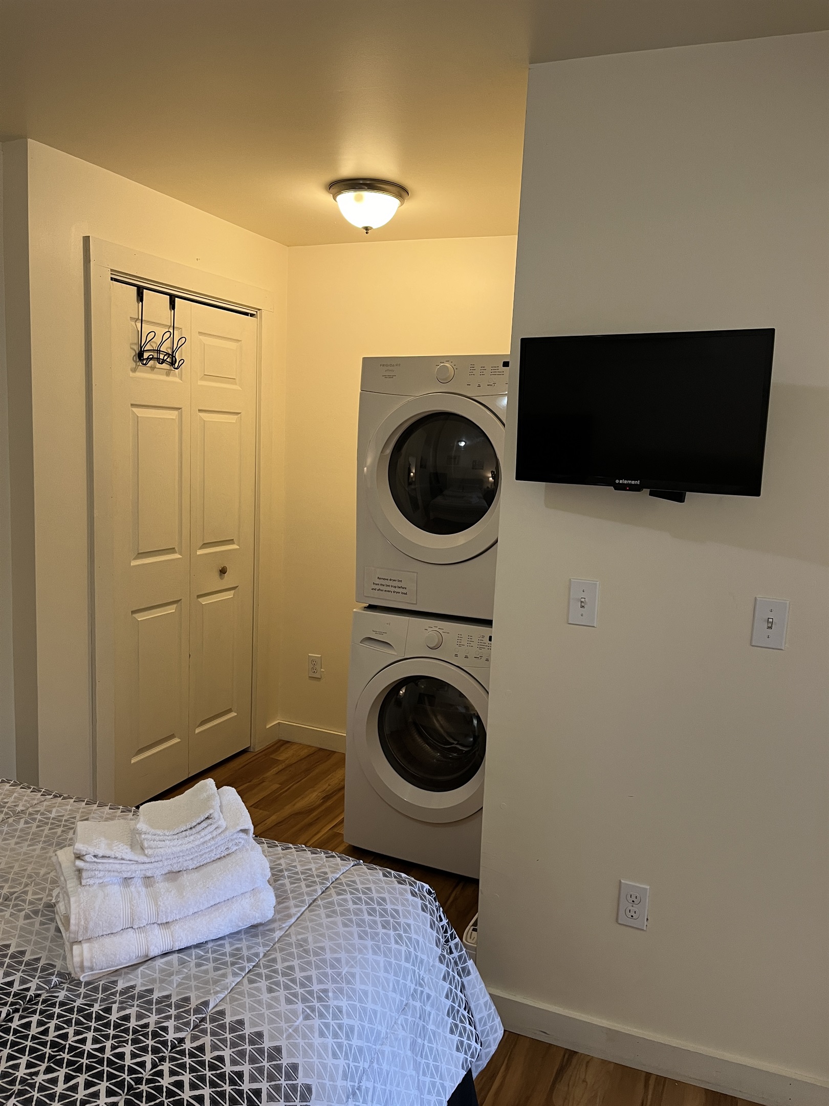 Queen sleeping area with laundry