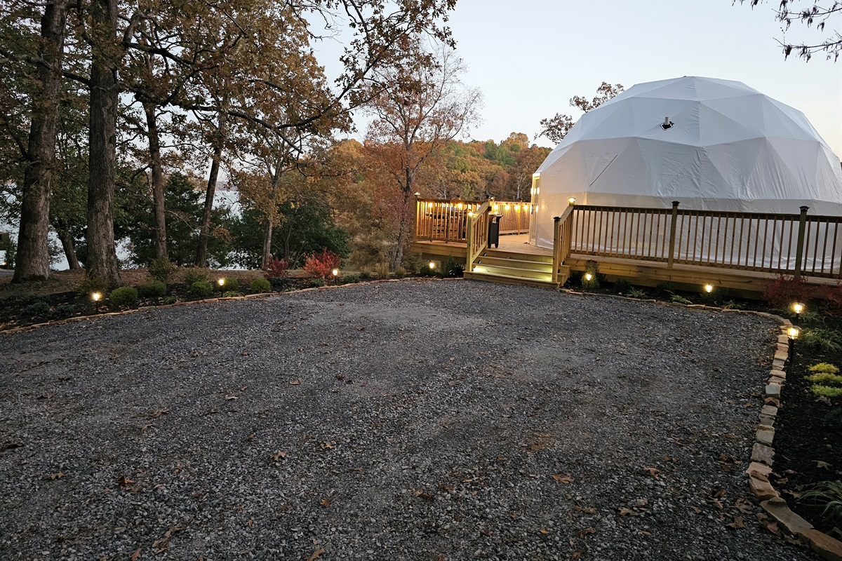 Evening arrival view — soft landscape lighting guides you to your private lakeside dome retreat