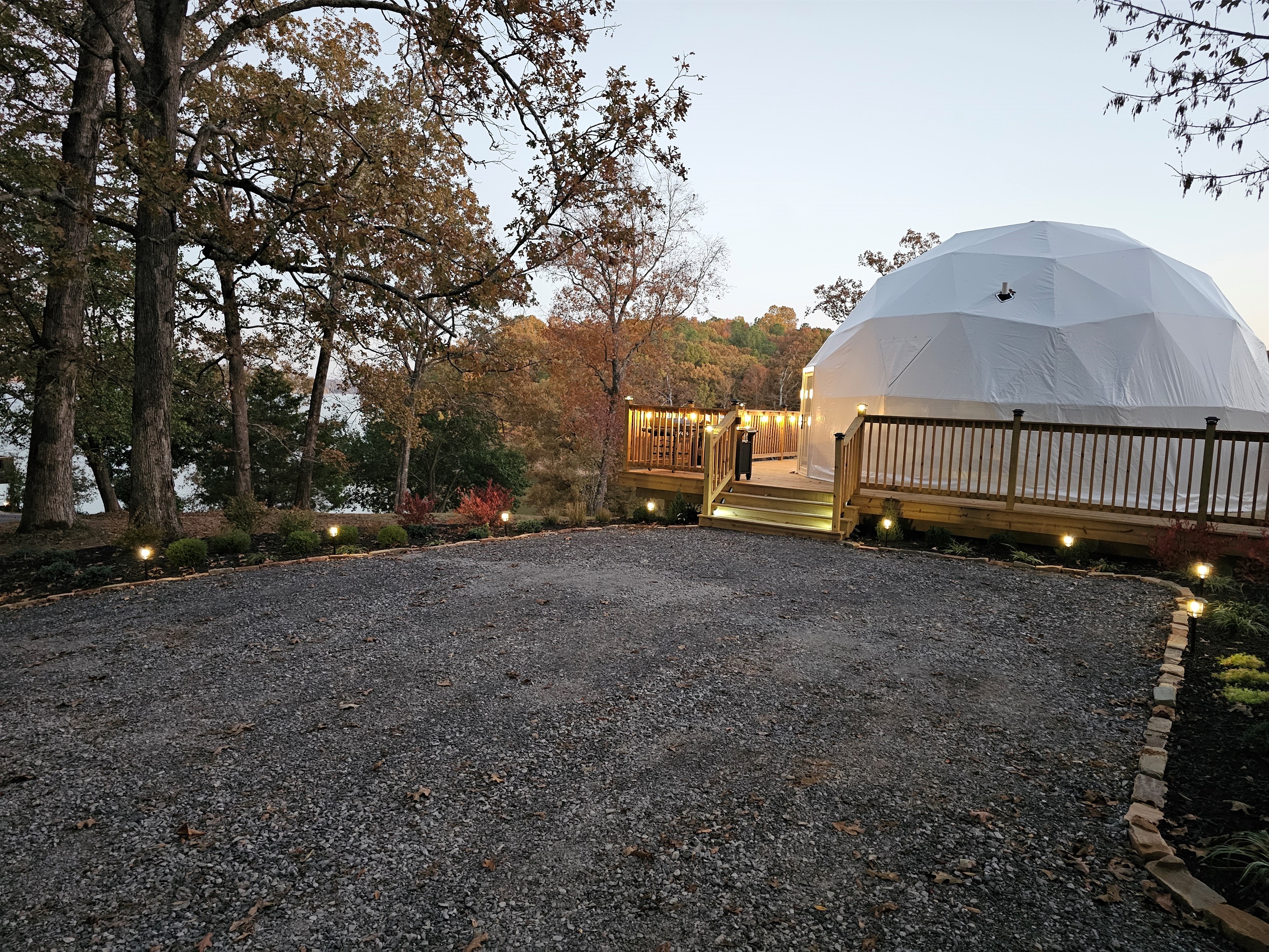 Evening arrival view — soft landscape lighting guides you to your private lakeside dome retreat