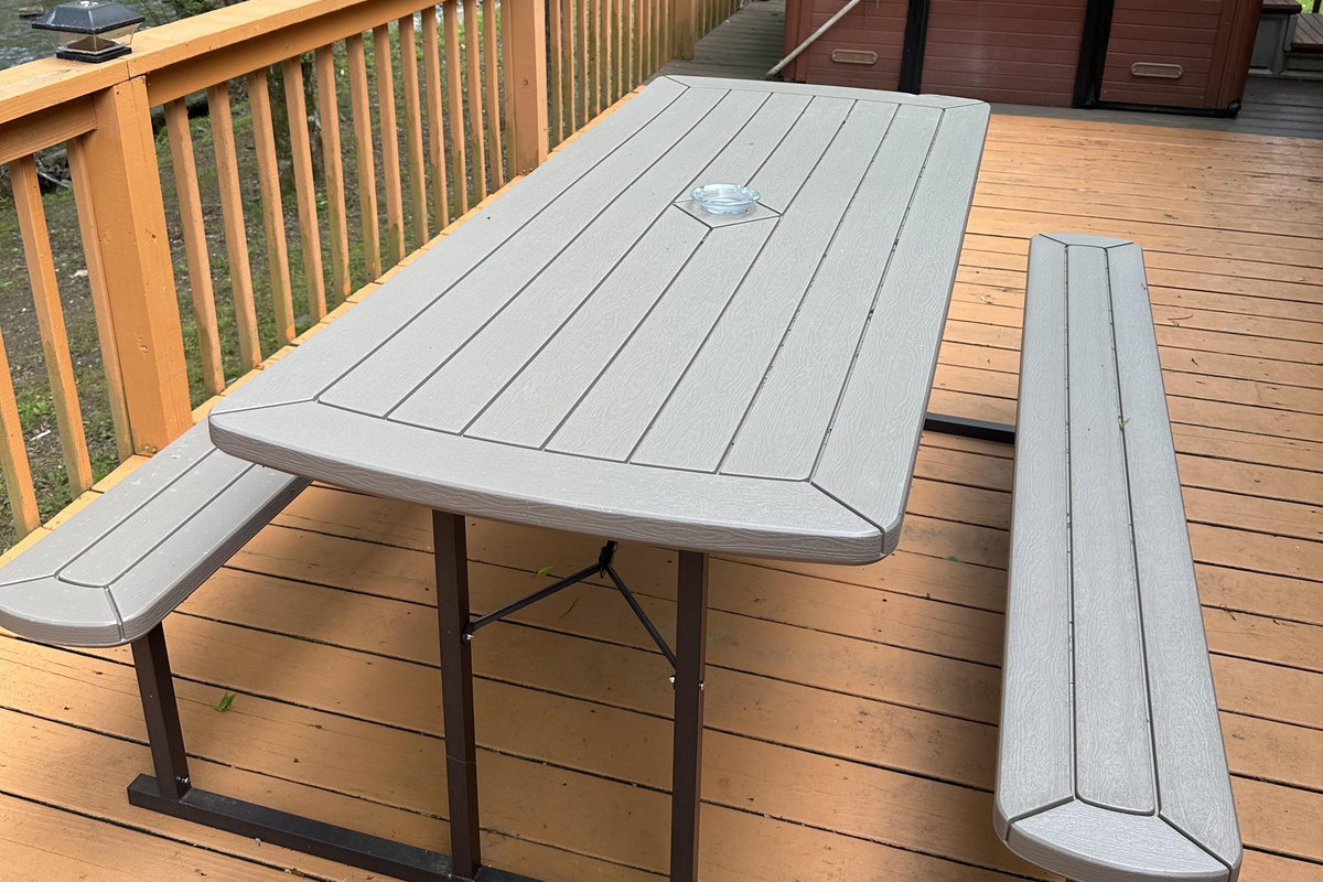 Enjoy outdoor dining on the spacious deck at Creekside Paradise, featuring picnic-style seating and a private hot tub at our Smoky Mountain cabin in Cosby, Tennessee.
