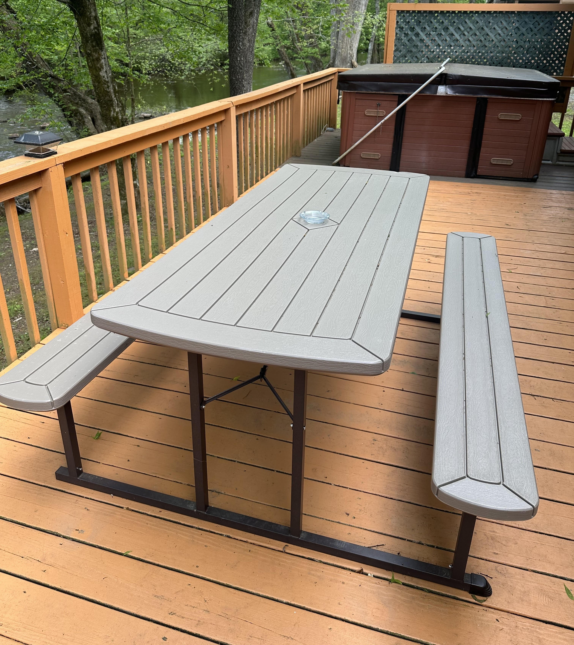 Enjoy outdoor dining on the spacious deck at Creekside Paradise, featuring picnic-style seating and a private hot tub at our Smoky Mountain cabin in Cosby, Tennessee.