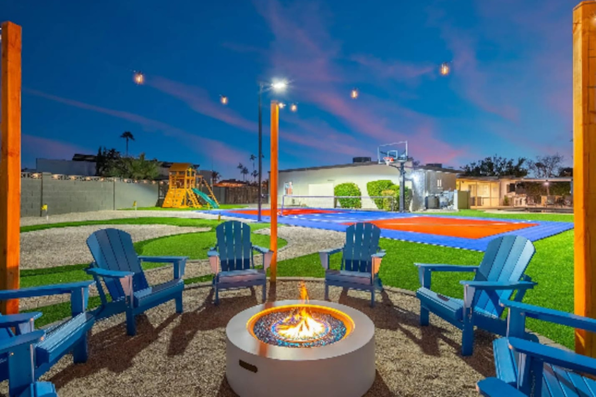 Evening falls and the fire pit lights up, with Adirondack chairs circled up for s'mores and storytelling. Just past the flames, a full sport court and play structure keep the fun going long after the sun sets.