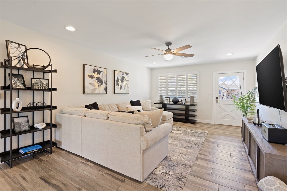 Open living room with large sectional seating, ceiling fan, perfect for gathering!