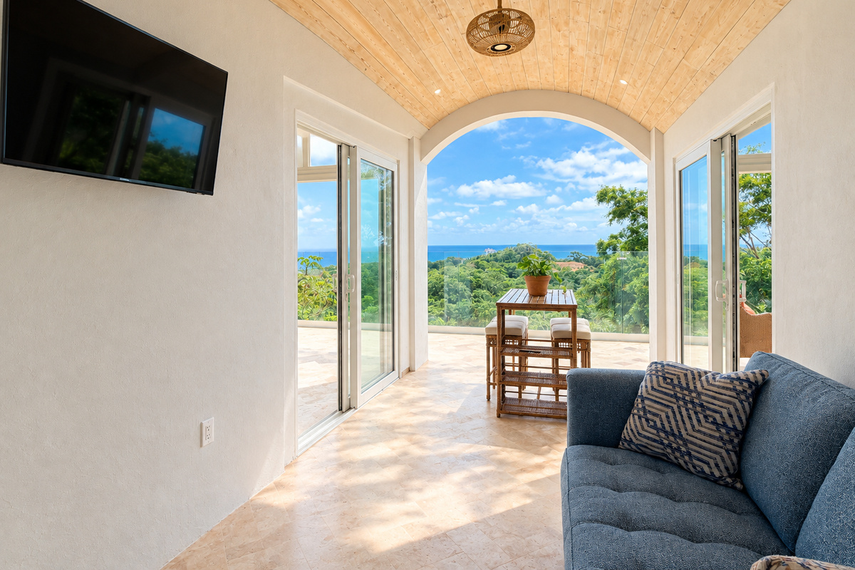 Breezeway between lower bedrooms with sofa and TV