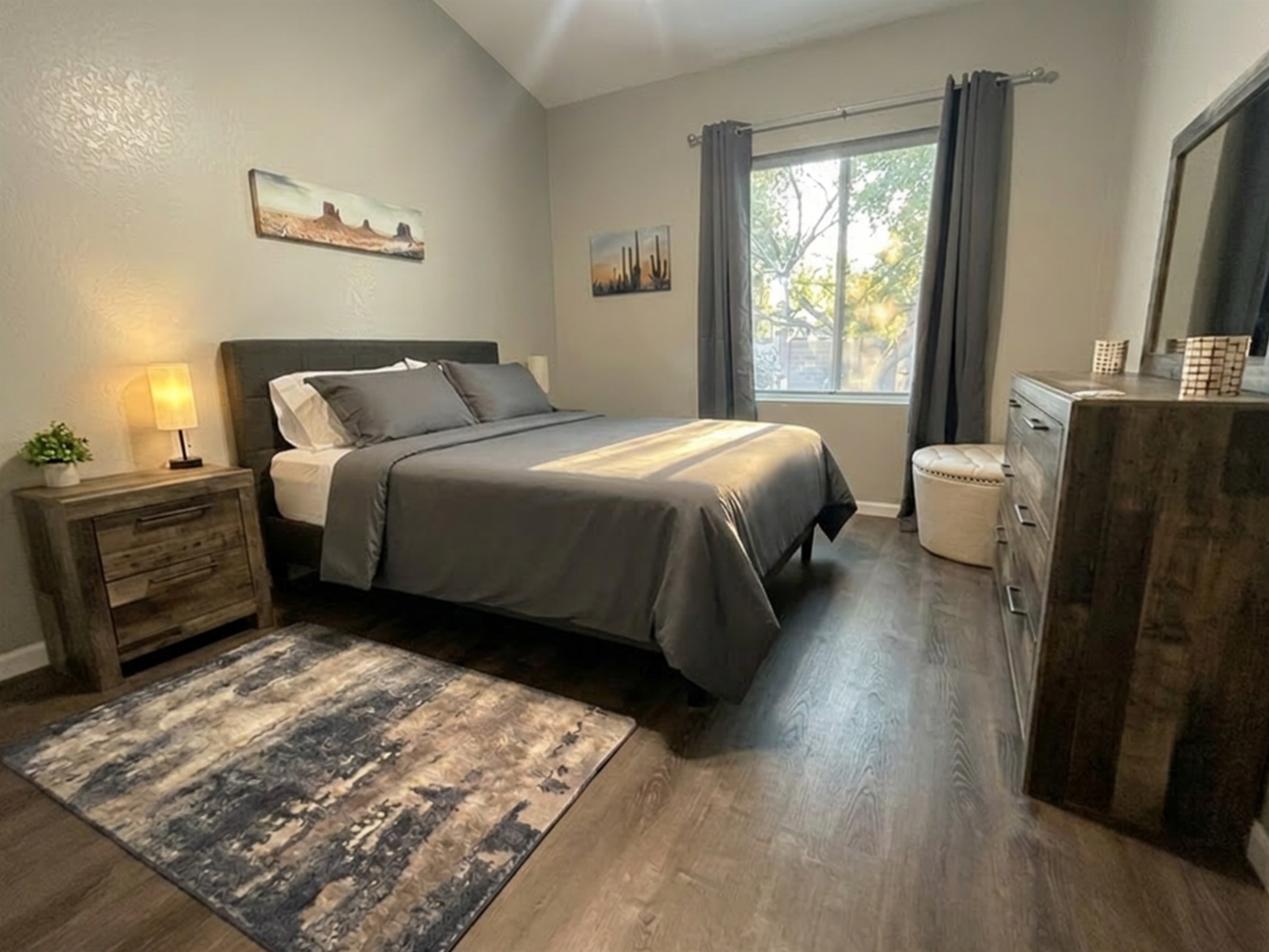 Bedroom #2:Comfortable queen bedroom with soft linens, warm lighting, and modern desert-inspired art. 
