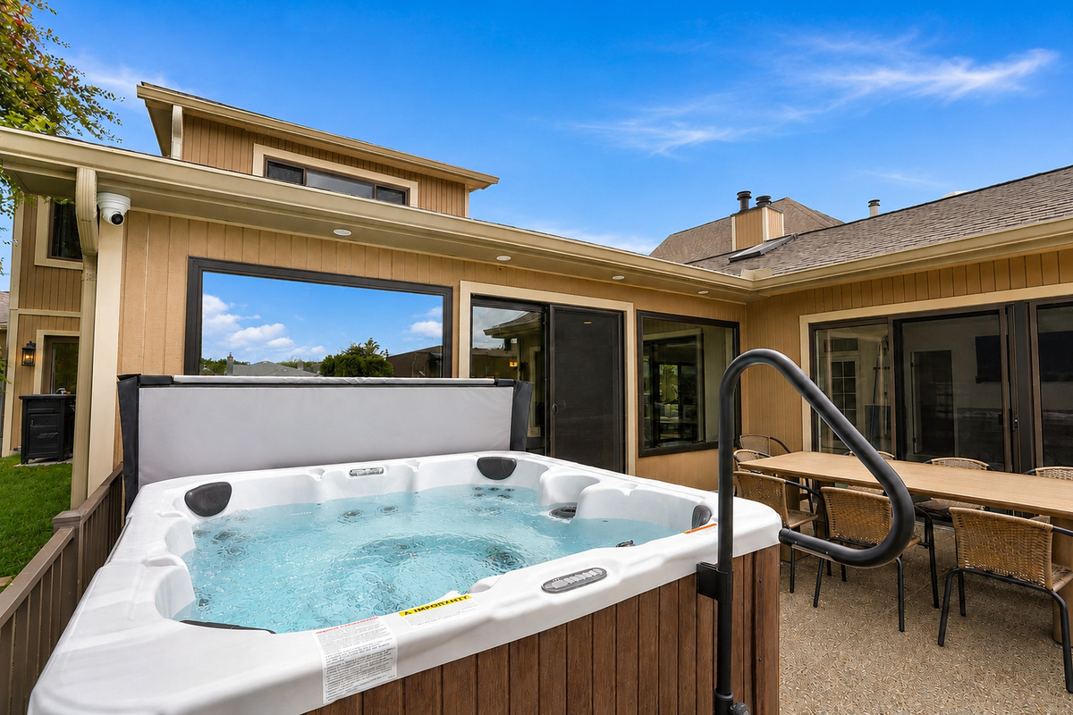 Private outdoor hot tub patio with seating and indoor-outdoor access. Relaxing, resort-style space perfect for unwinding and enjoying a peaceful stay.