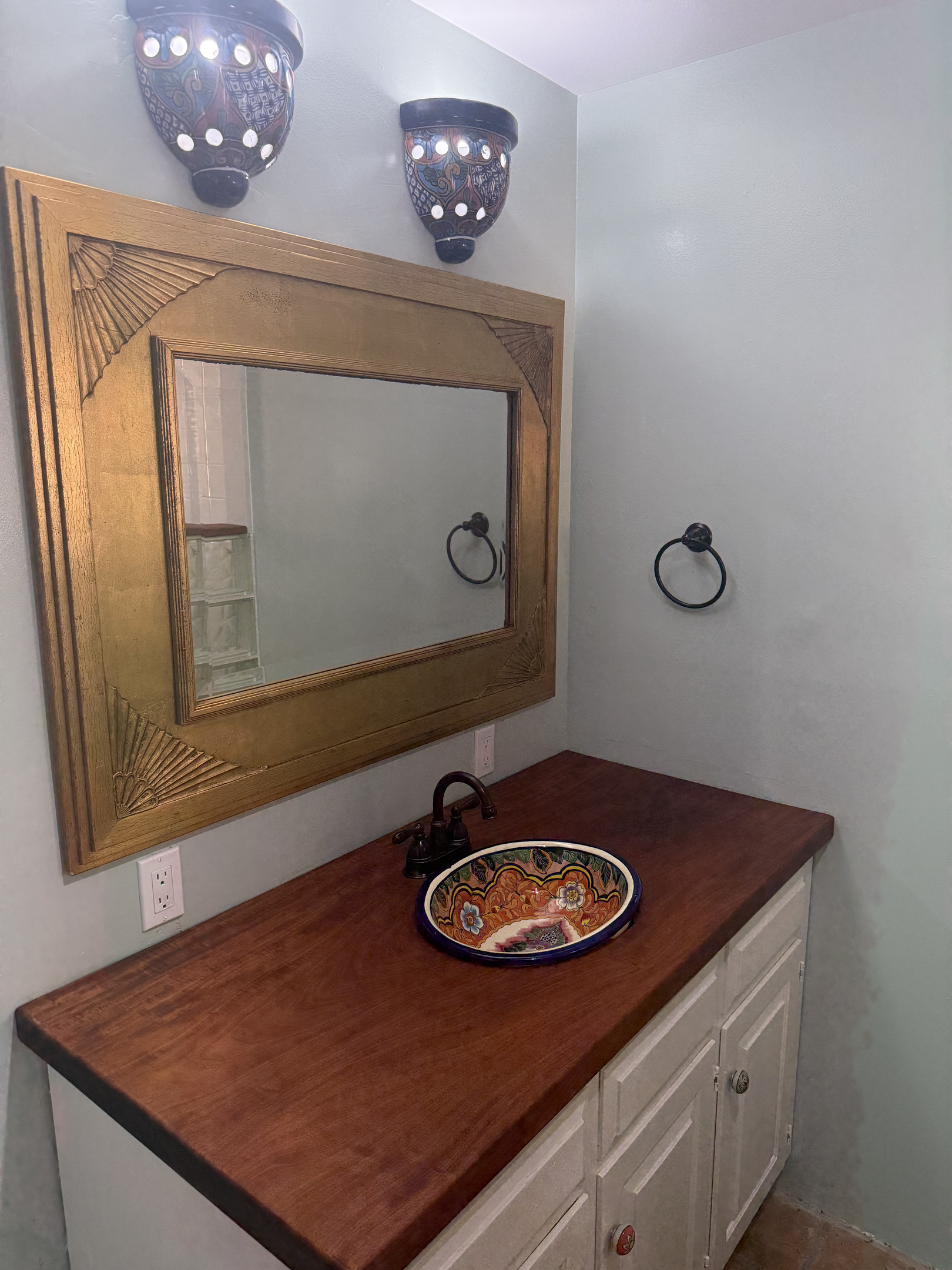Primary bathroom features a handcrafted Talavera ceramic sink, locally sourced mahogany countertop, and unique artisanal fixtures for a perfect blend of tropical warmth and character.