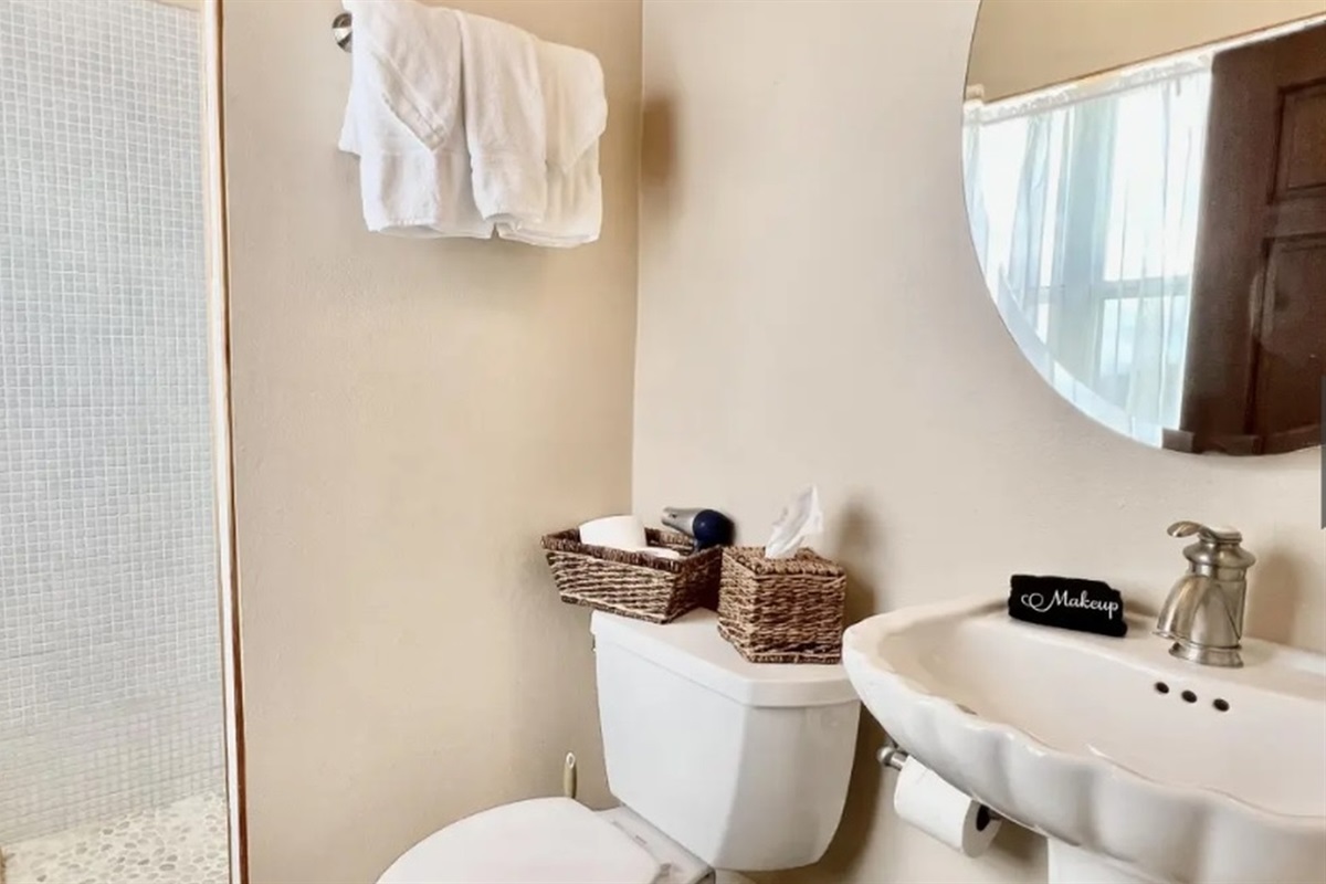 Fresh, coastal-style bath with plush towels and thoughtful touches for a spa-like feel.