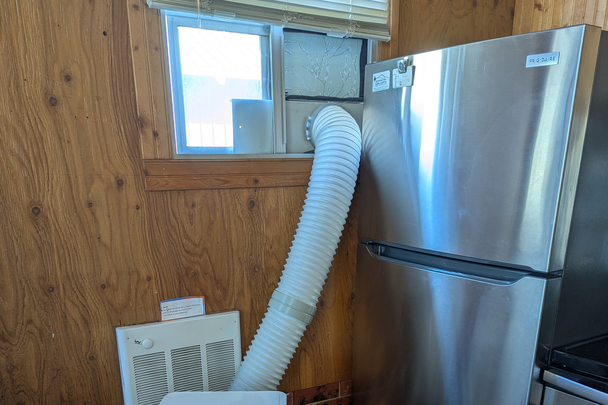 Portable AC. The only window for install. Please be careful in opening the refrigerator doors! This does not cool the upstairs. There are windows on each end upstairs that open plus fans and a small water cooler on the nightstand.