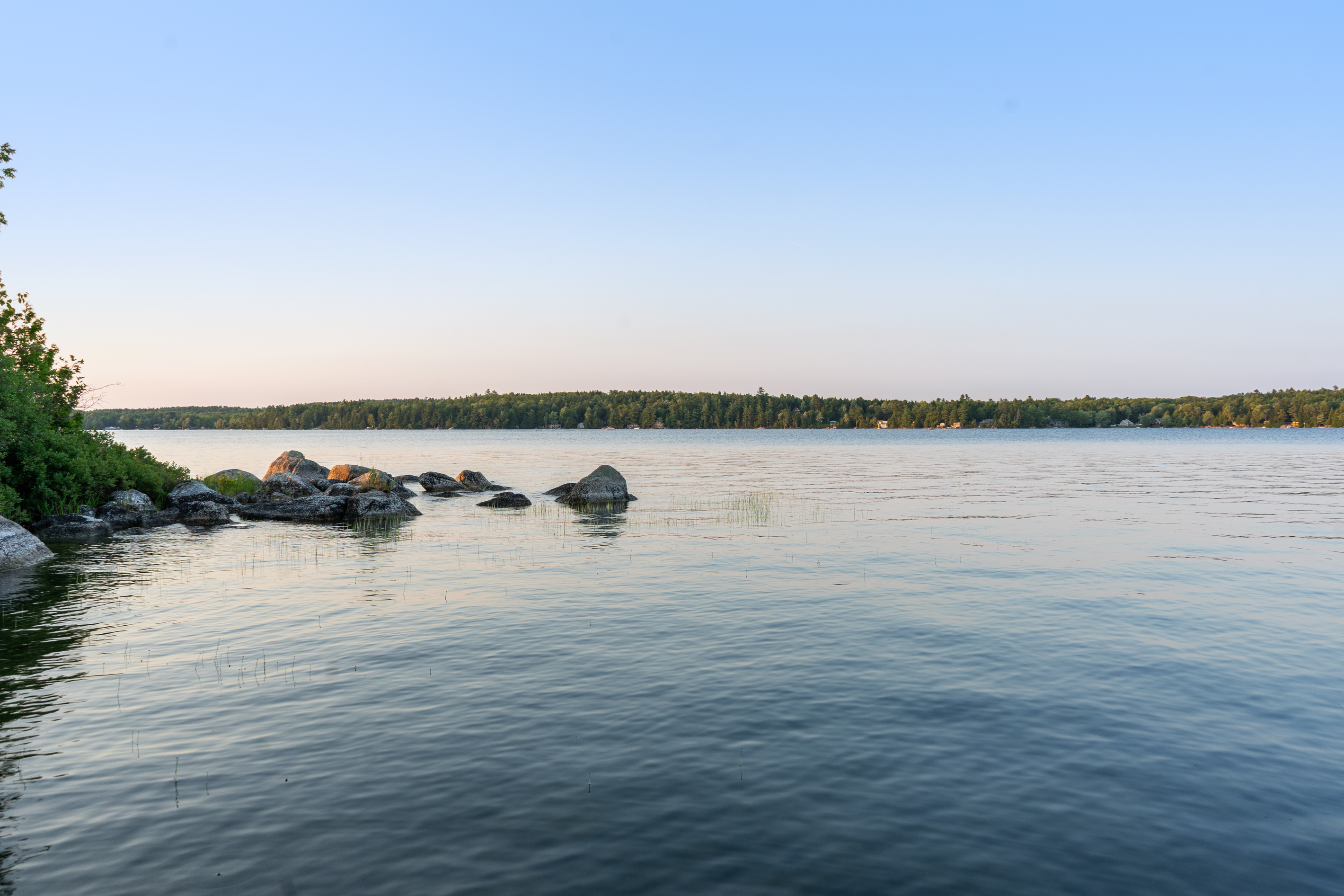 Looking left from the private dock out of the cove at Loonrise Point! Features natural granite boulder clusters lining the shore and calm open waters. Great spot for casting a line on Beech Hill Pond, just 20 mins to Ellsworth.