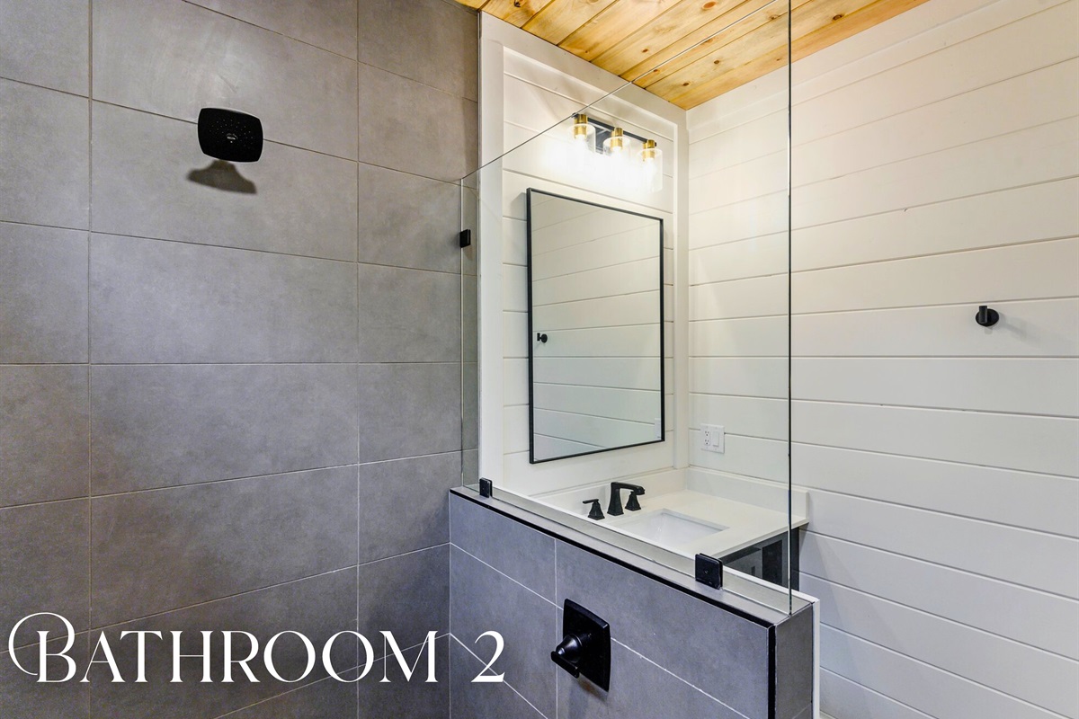 Bathroom 2 includes a large walk-in shower and sleek black fixtures—everything you need to refresh and unwind.