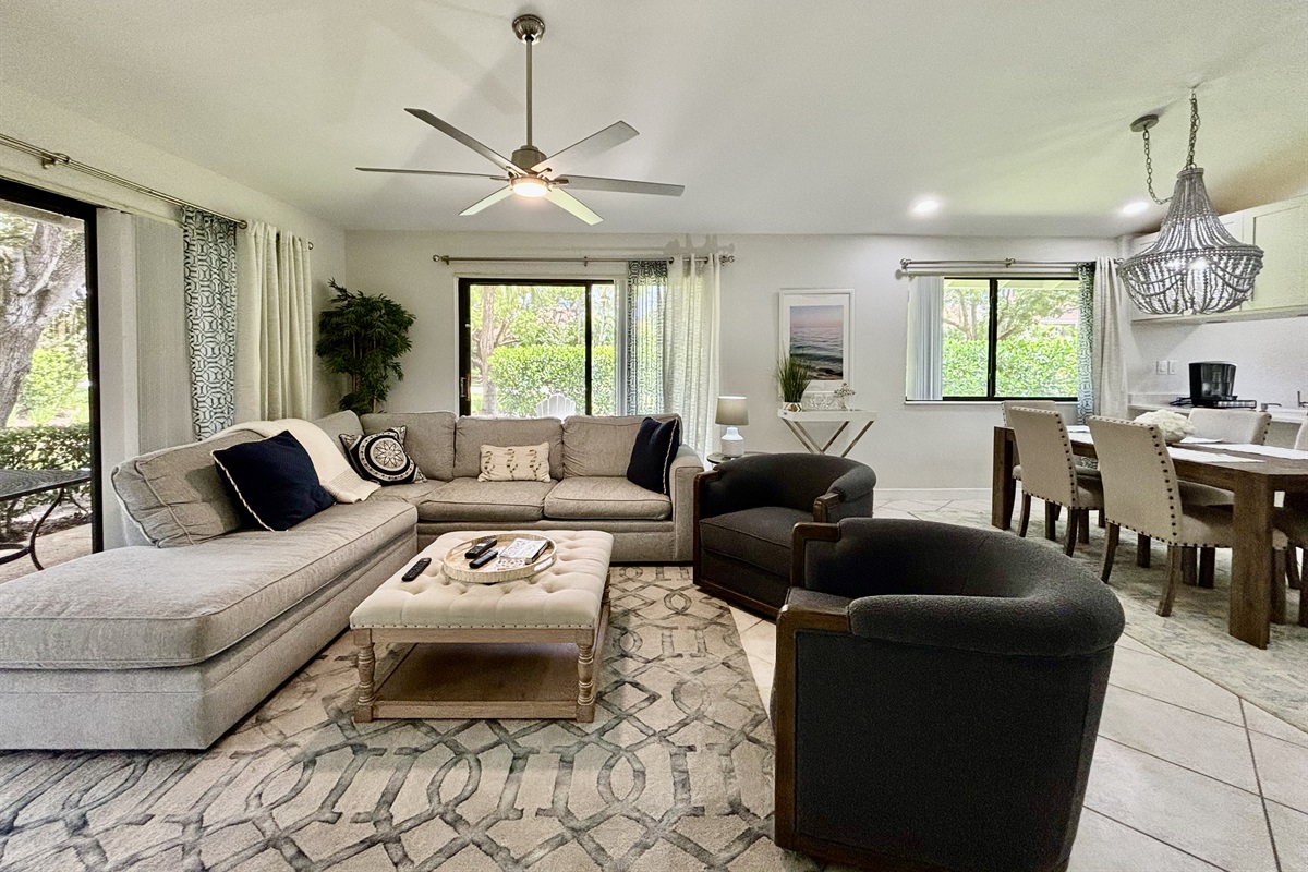 Our large, open living room has seating for six in front of the TV. Two large sliding glass doors let in plenty of light and views of the surrounding, peaceful landscaping.