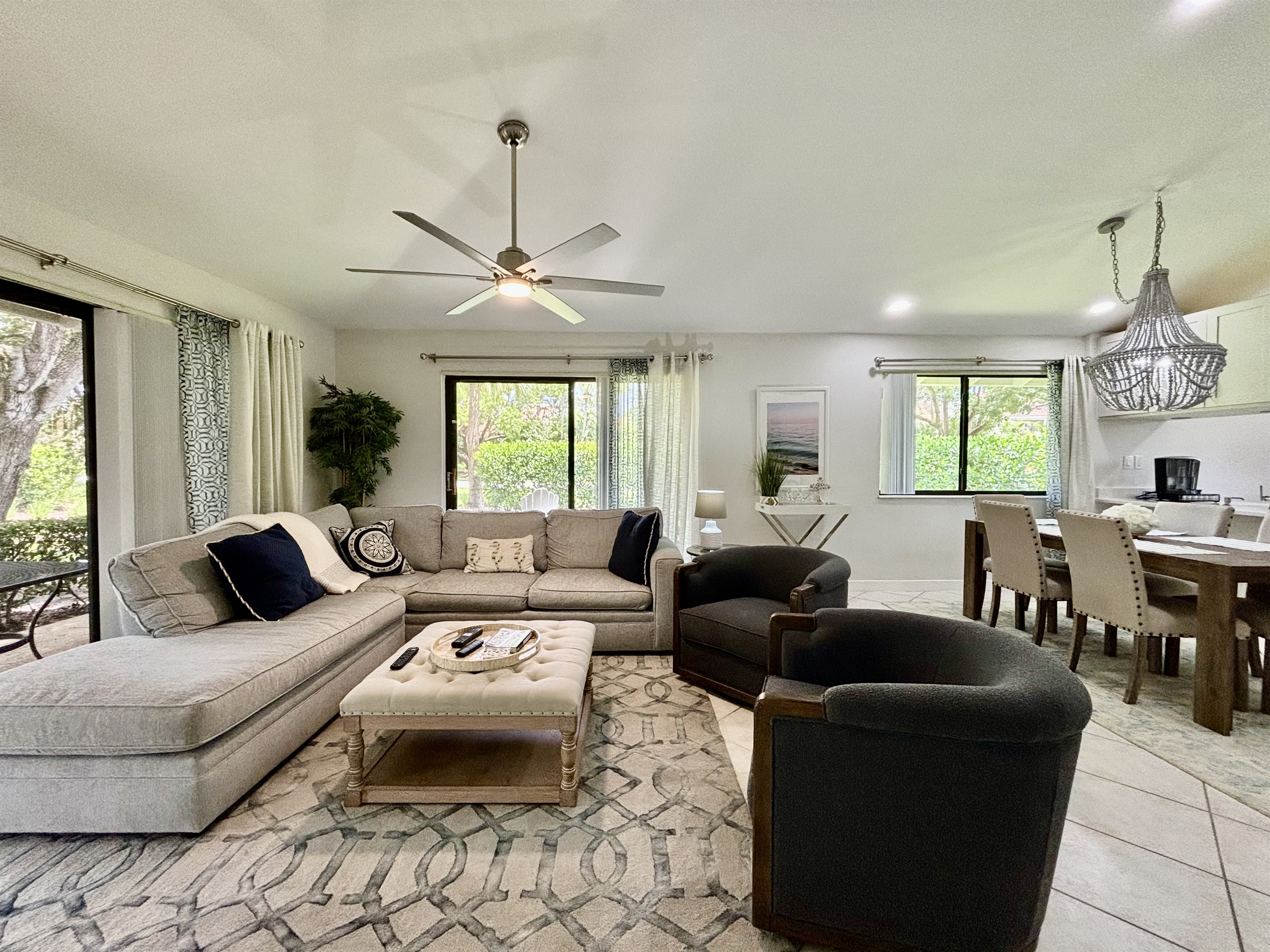 Our large, open living room has seating for six in front of the TV. Two large sliding glass doors let in plenty of light and views of the surrounding, peaceful landscaping.