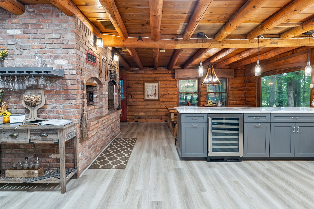 Warm brick accents and wood-beam ceilings create a welcoming kitchen and dining space designed for gathering and entertaining.