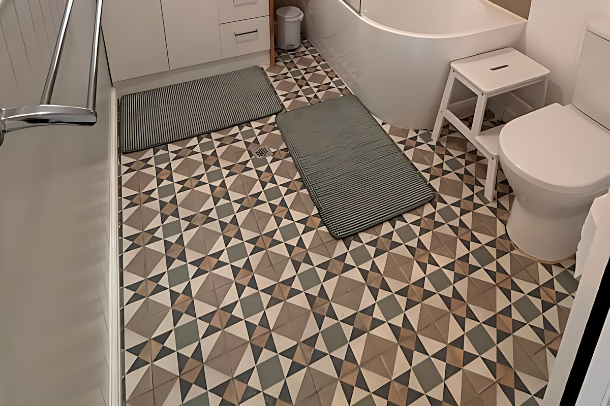 The main bathroom at Lake Views & Coastal Escape has a shower over a corner bath, a vessel basin on a timber-topped vanity, a toilet, a step stool and patterned floor tiles.