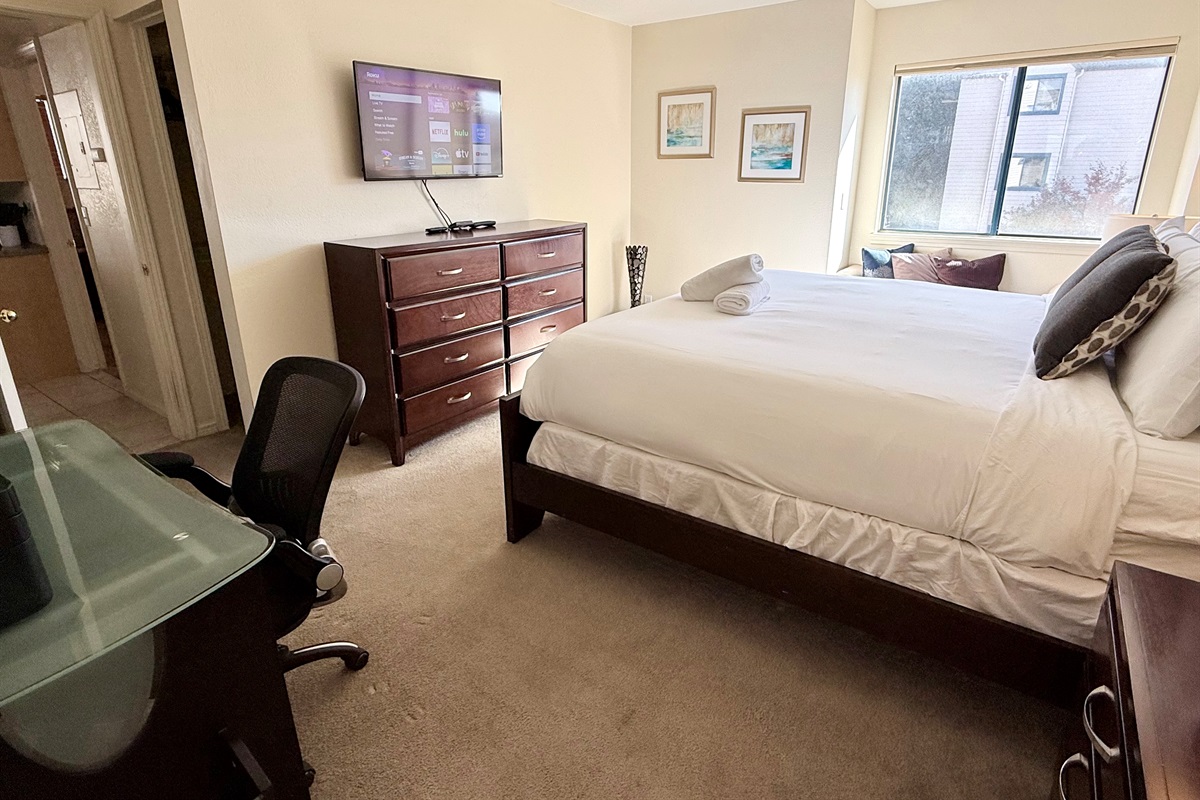 Oversized primary bedroom with office area, plenty of space, dresser, walk in closet, window bench and attached bathroom.