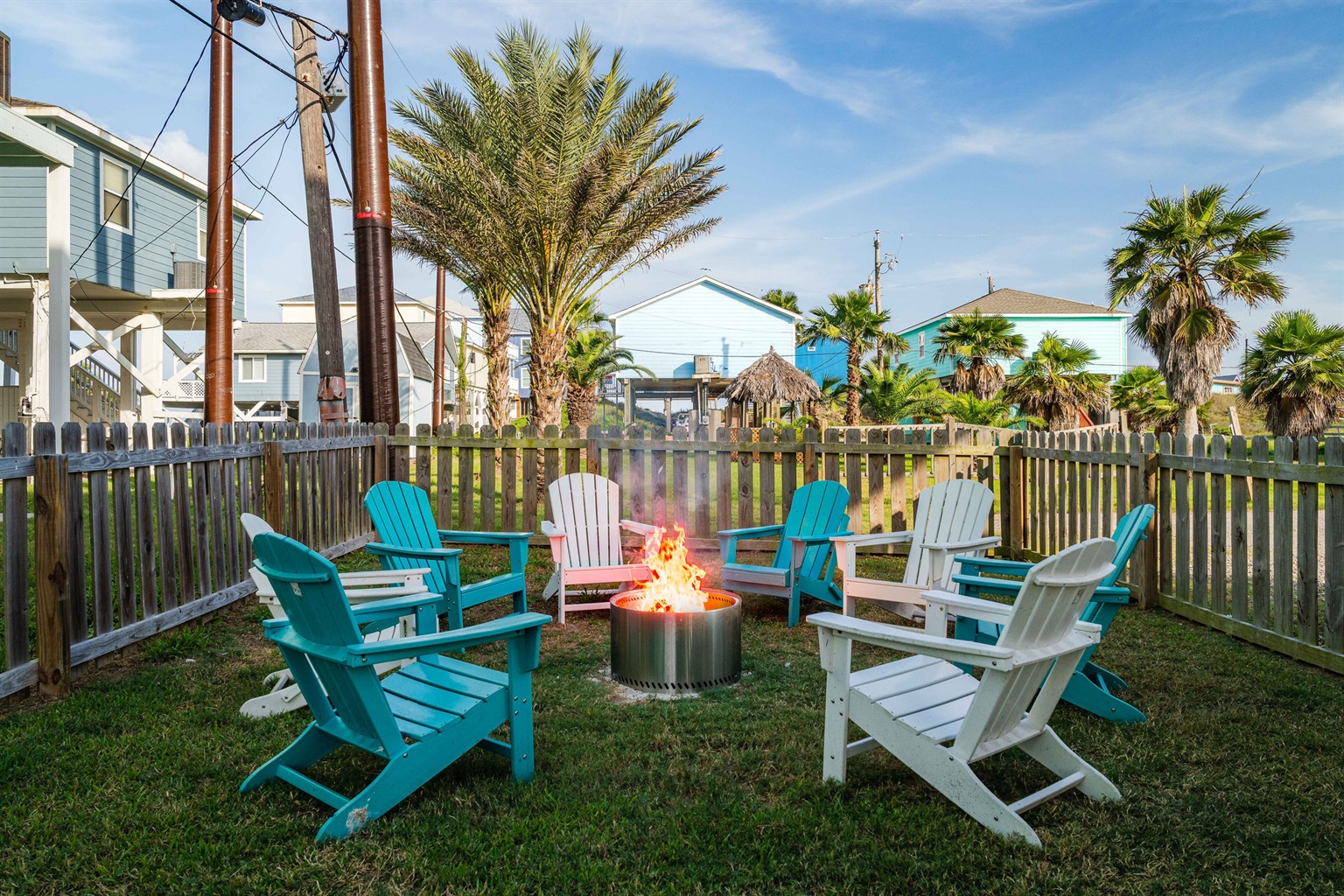 Firepit circle with Adirondack chairs — seats the whole group. S'mores, stars, and stories after a long beach day.