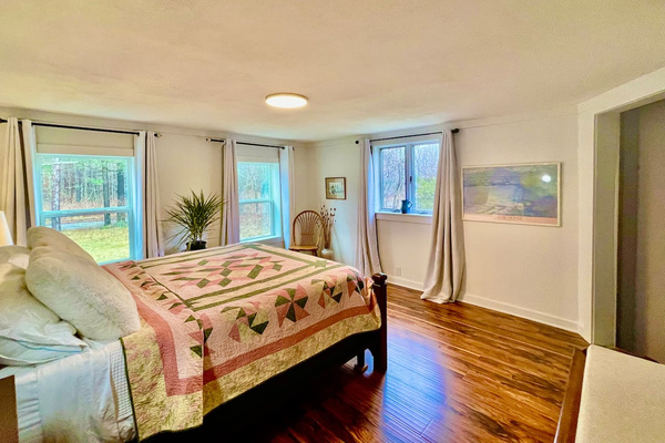 Comfy mattress and cotton sheets atop a California King mattress. Blackout curtains for sound sleep. (second view of lower bedroom)