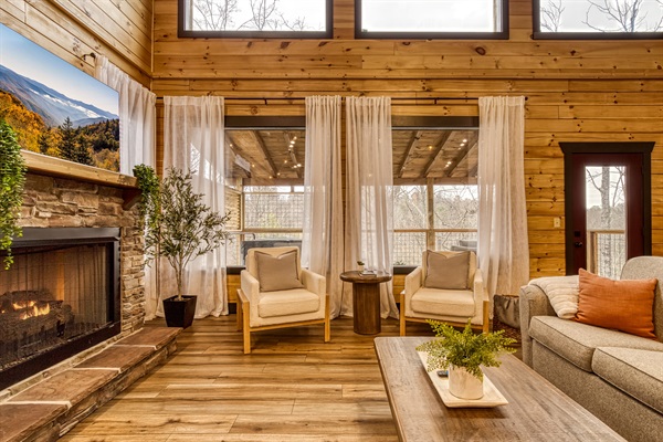 Cozy up in the living room where soft lighting, warm wood, and a crackling fire make every night feel special