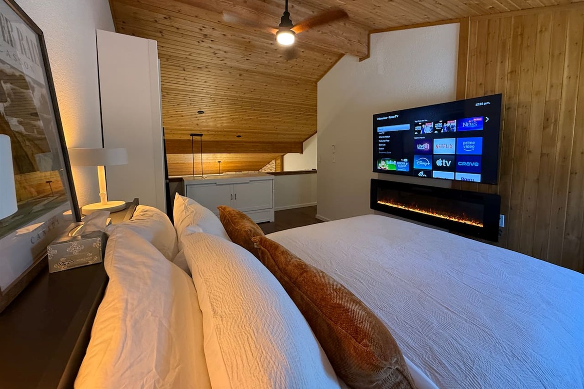 Loft Bedroom Entertainment: Stream your favorite shows on the smart 65" TV enjoying the ambiance of the fireplace. 