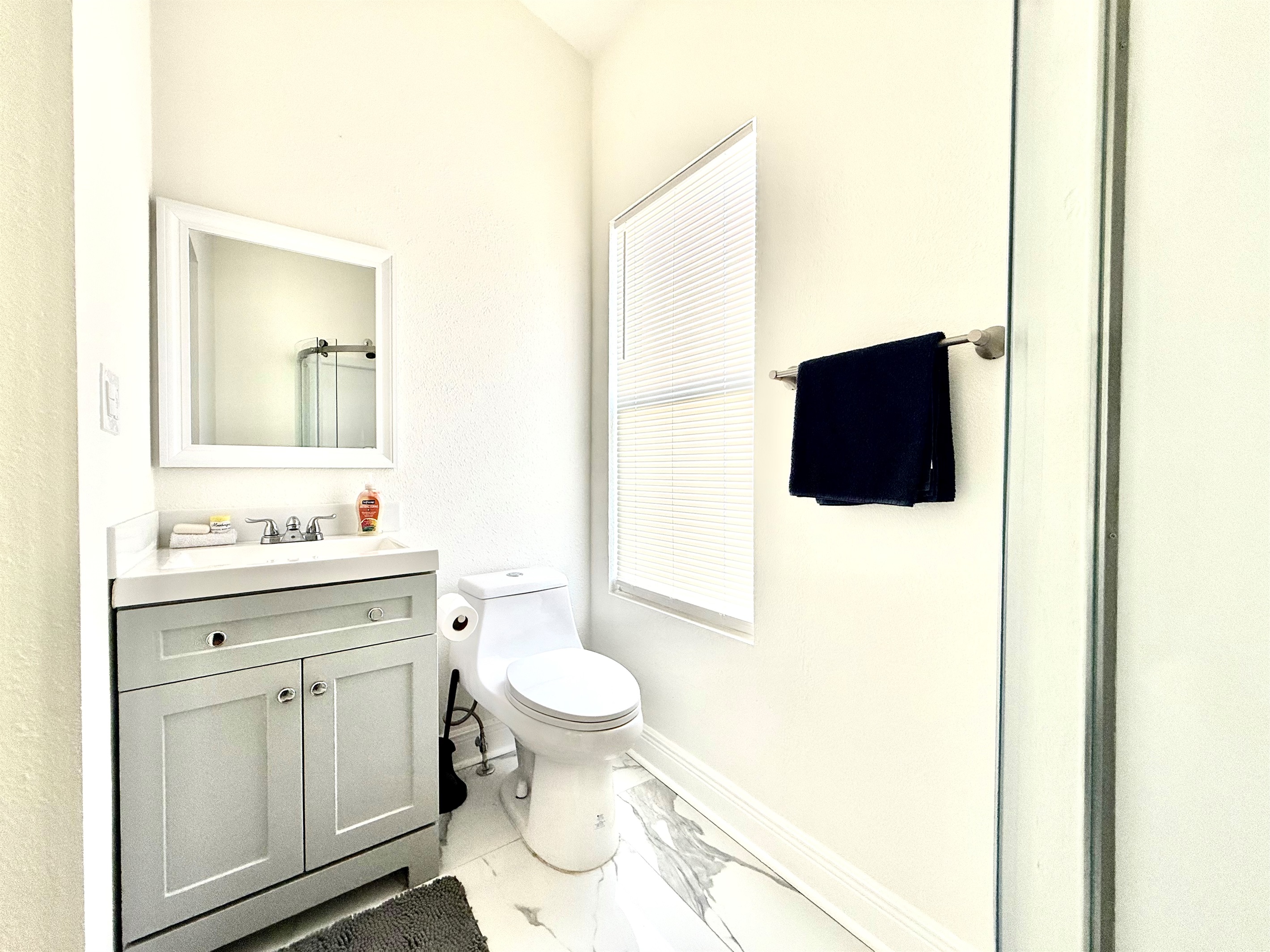 Compact yet stylish, this bathroom features a sleek glass-enclosed corner shower with built-in shelves and premium soap dispensers—ideal for a refreshing rinse after a day of adventure.
