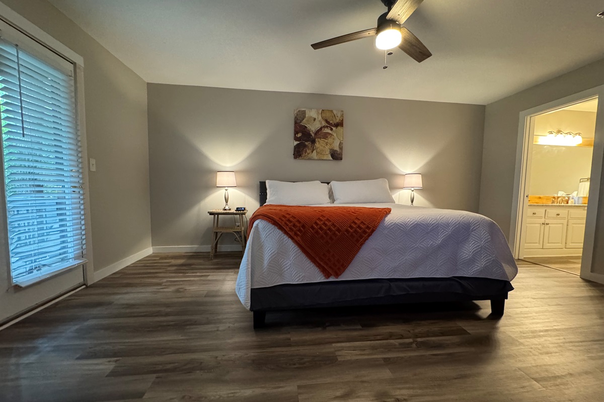 Enjoy the spacious bedroom with king bed, ceiling fan, and ensuite bath—plus direct access to the patio.