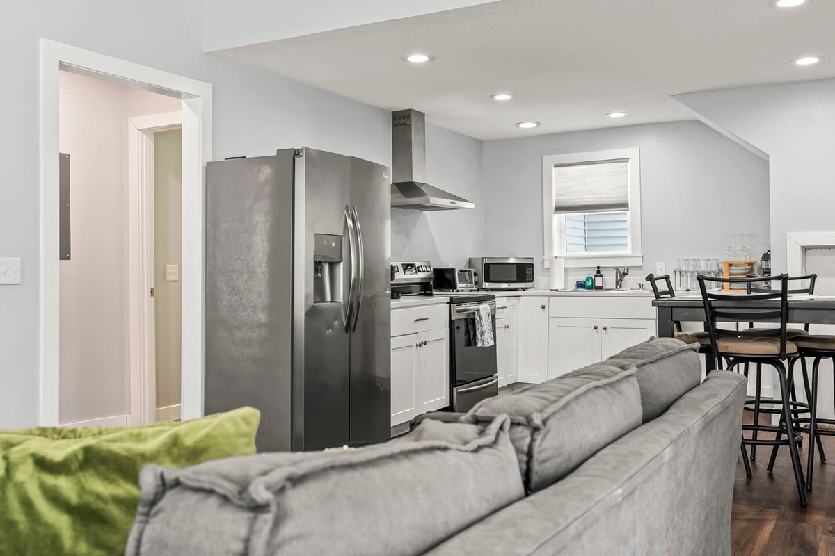 Open kitchen view from the living room showcasing stainless steel appliances, modern cabinetry, and an easy, open-concept layout.