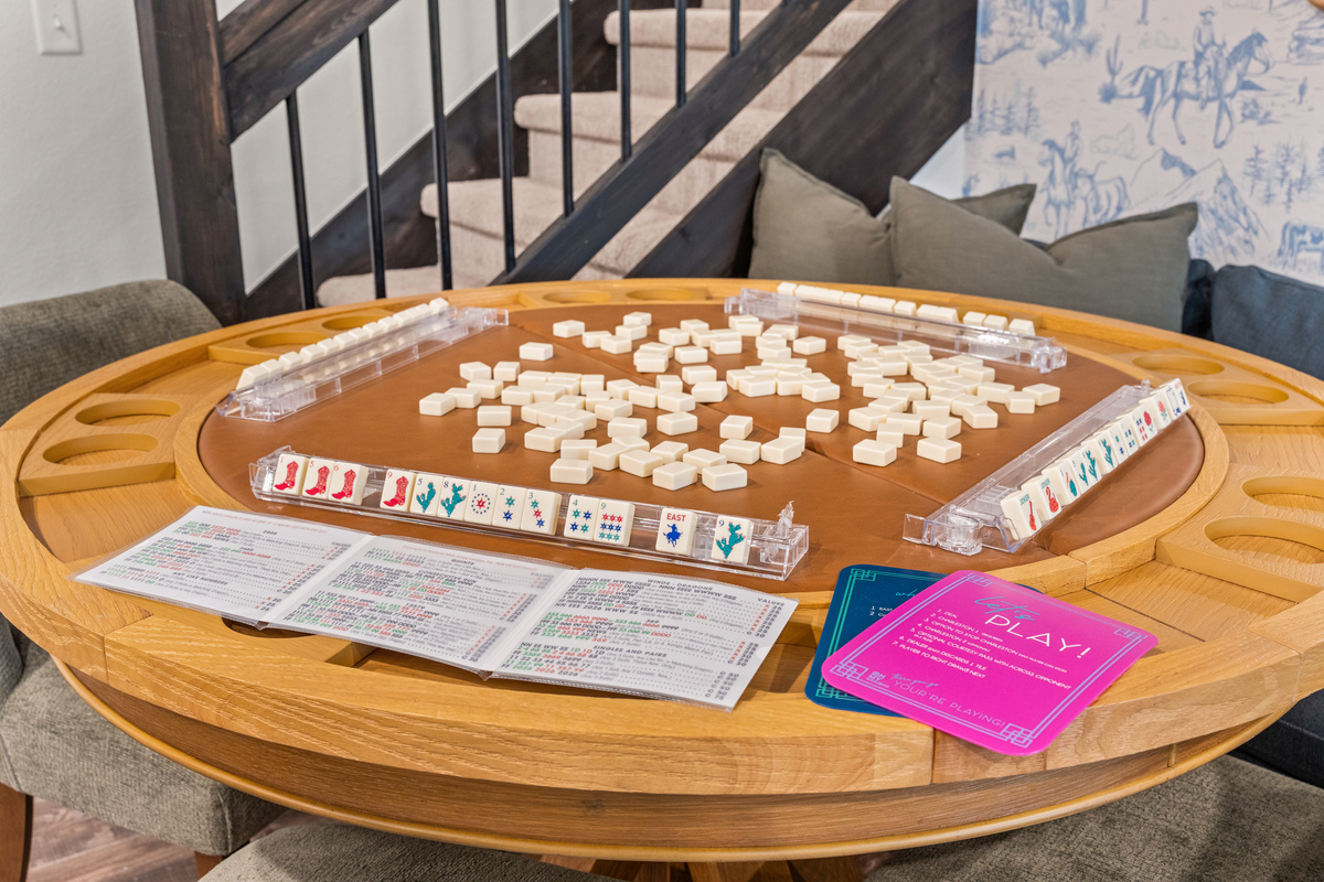 Set up a round of mahjong on the barrel game table, with tiles, racks, and a cheat sheet included.
