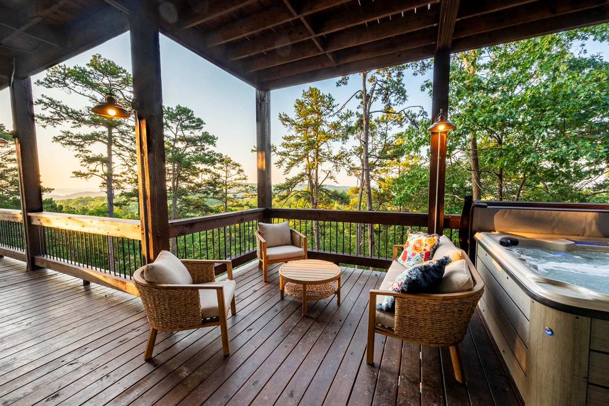 Spacious deck retreat featuring hot tub, lounge seating, and sunset views
