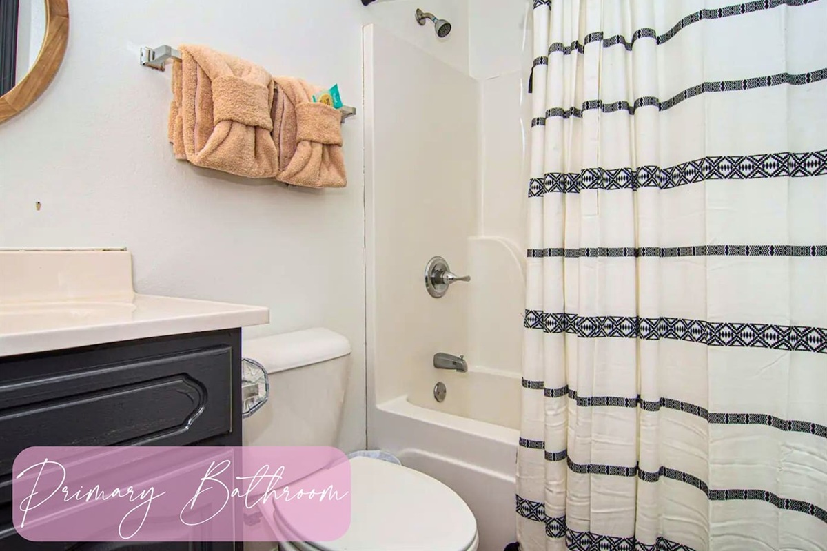 Freshen up in the primary bathroom, where clean lines and a crisp shower curtain create a refreshing space to rejuvenate.