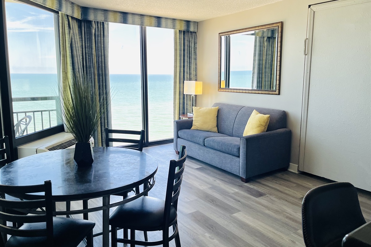 Experience open-air comfort in the living area, where the sliding glass doors bring in the coastal breeze, creating a refreshing and inviting space.