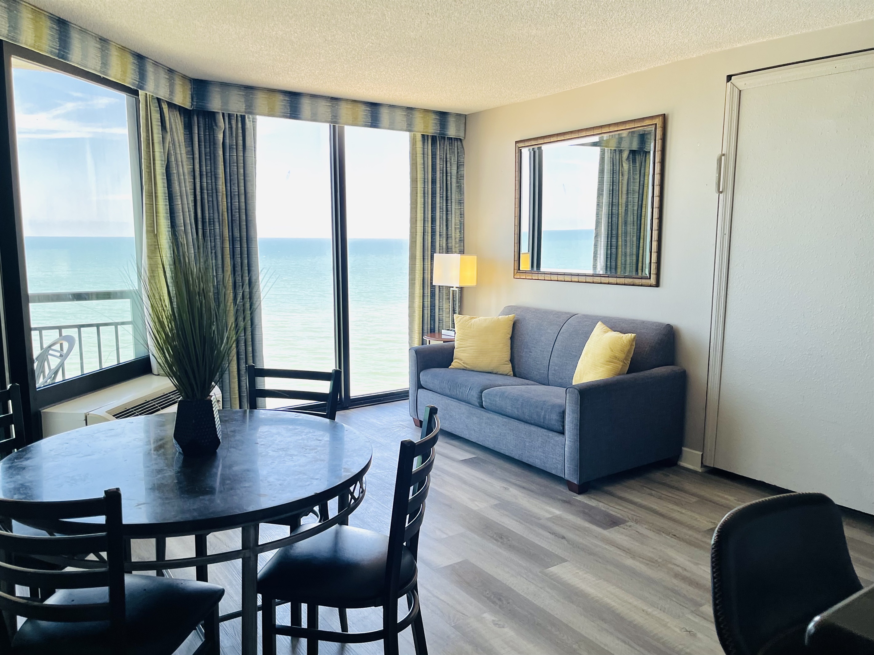 Experience open-air comfort in the living area, where the sliding glass doors bring in the coastal breeze, creating a refreshing and inviting space.